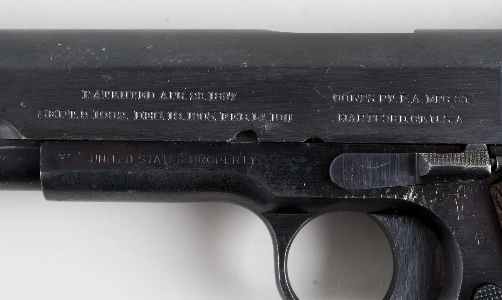 Close photograph of Colt M1911 slide markings and worn metal.